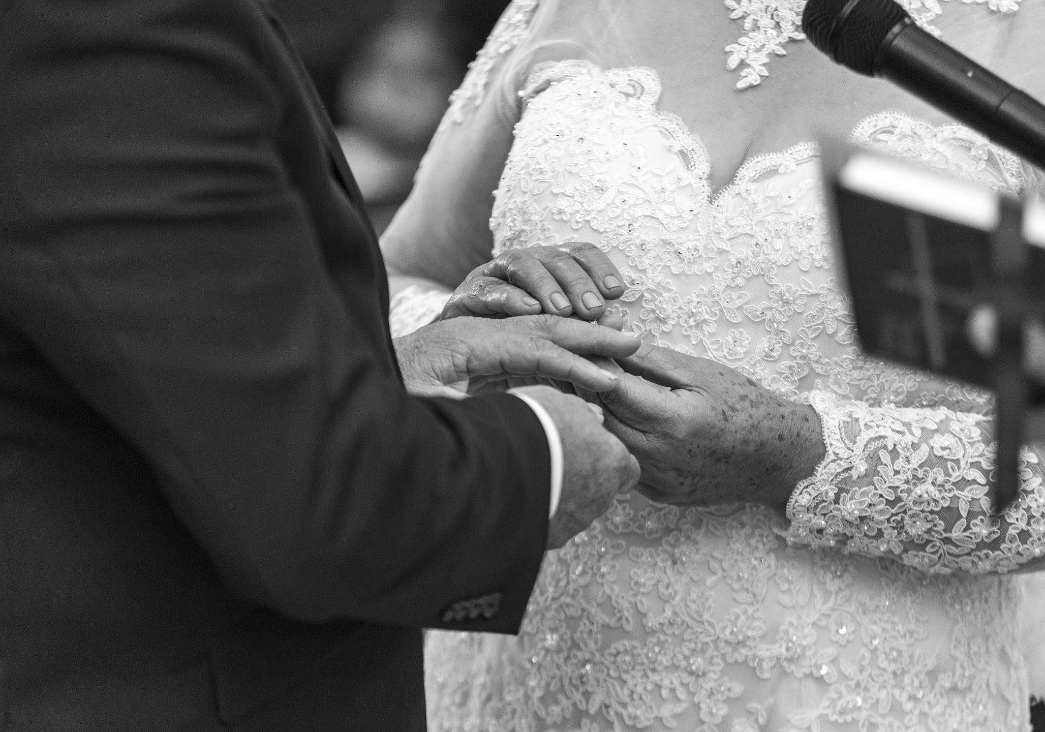 Black and white close-up of a couple exchanging a ring