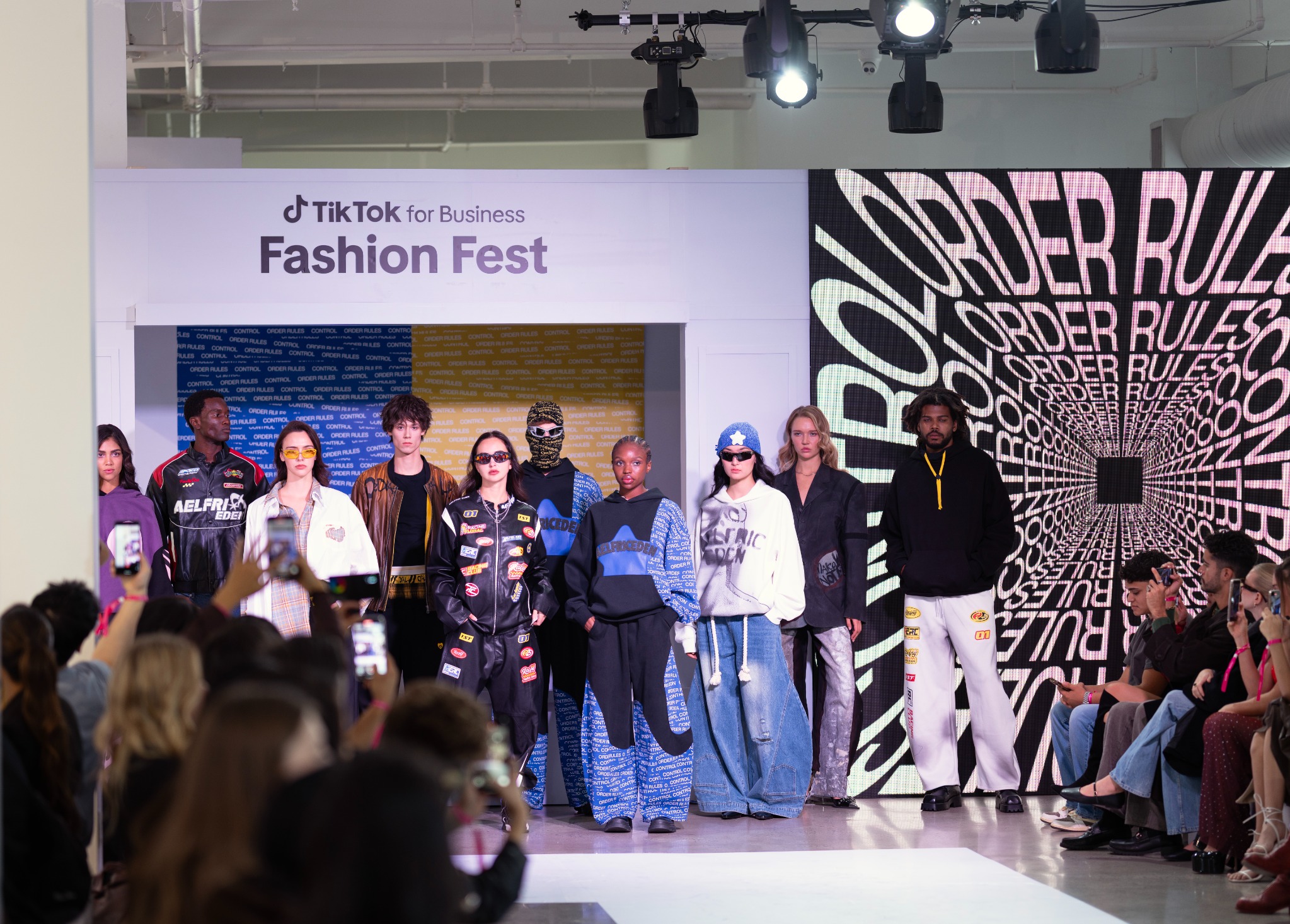 Fashion designers and models gathered at the end of a live runway presentation