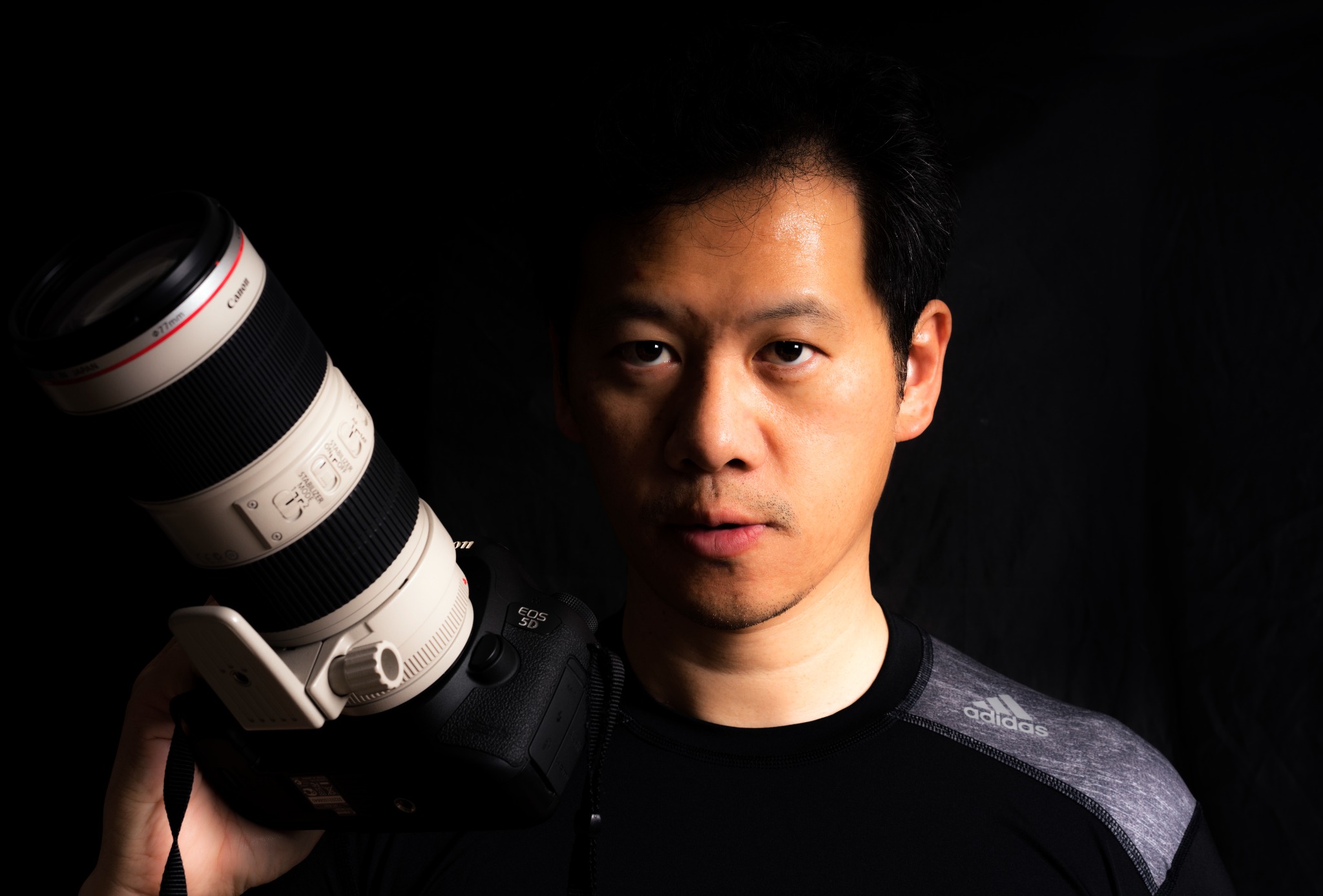 Frank holding his Canon camera, the photographer behind Synergy Photography